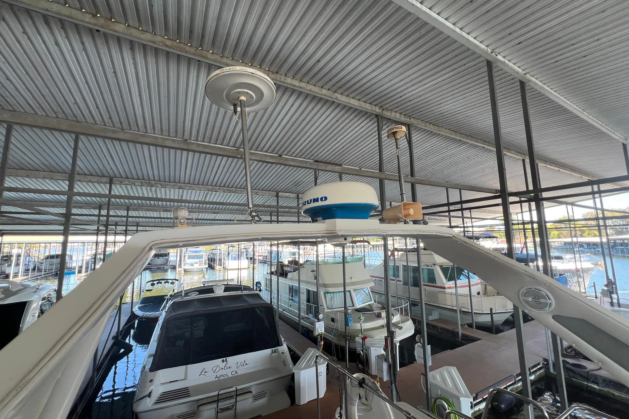 1986 Bayliner 4550 Motoryacht docked in a covered marina with other boats.
