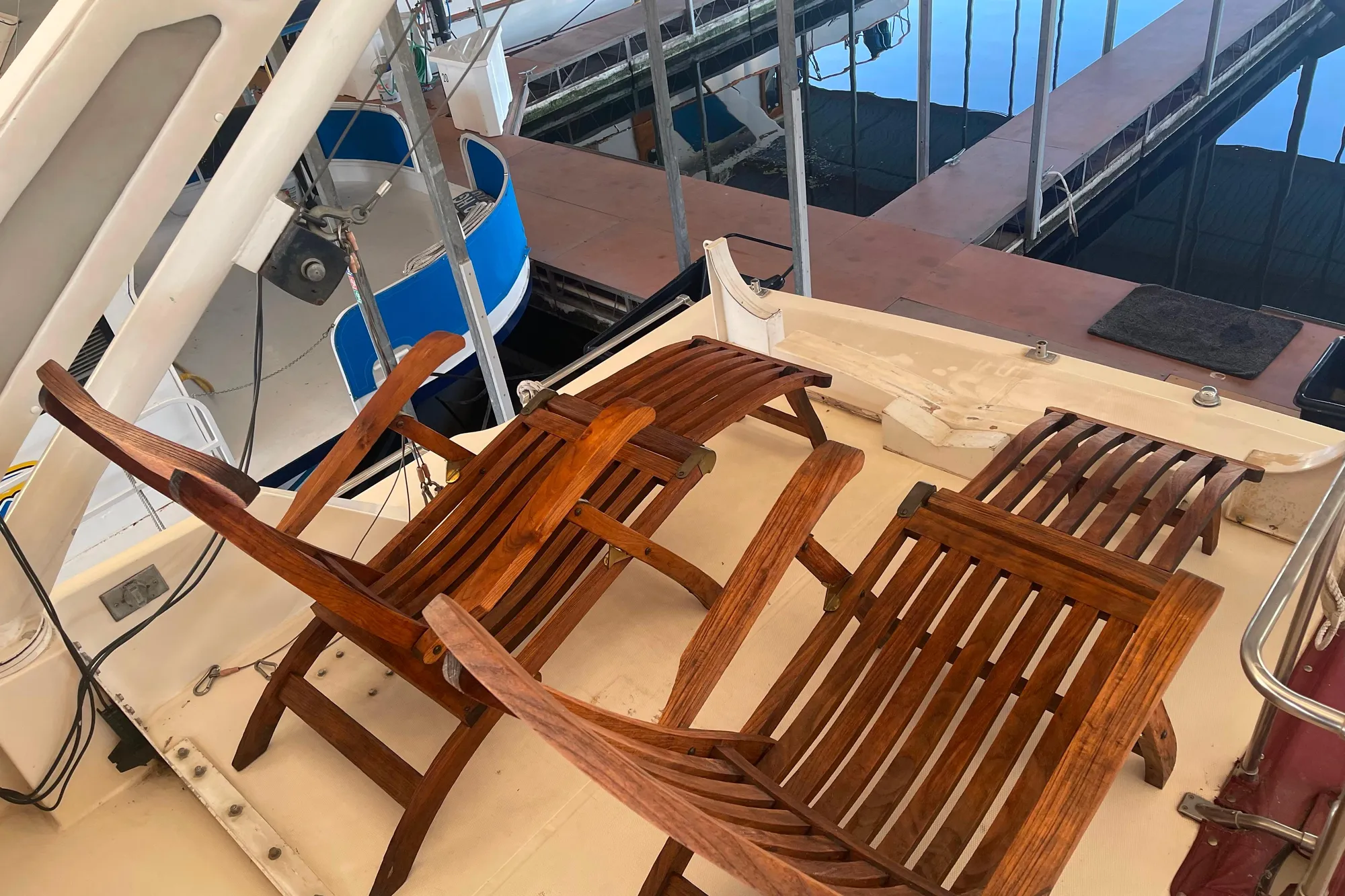 1986 Bayliner 4550 Motoryacht deck with wooden chairs, docked at marina.