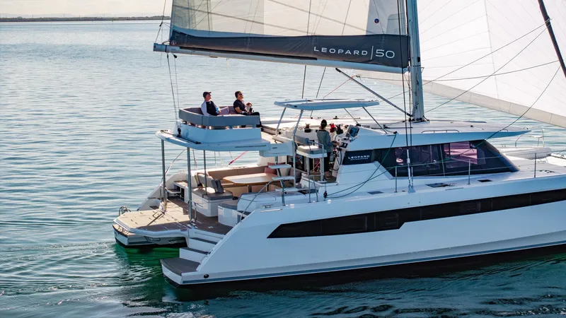  Yacht Photos Pics 2024 Leopard 50 catamaran sailing on calm waters, featuring spacious deck and modern design.