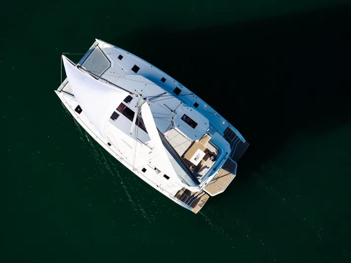  Yacht Photos Pics Aerial view of 2024 Leopard 50 catamaran sailing on calm green waters.