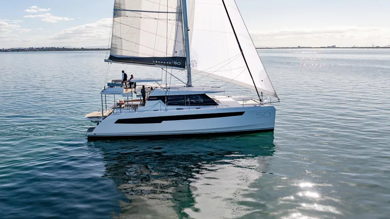  Yacht Photos Pics 2024 Leopard 50 catamaran sailing on calm waters under clear skies.