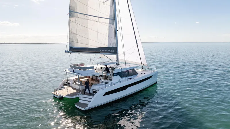  Yacht Photos Pics 2024 Leopard 50 catamaran sailing on calm waters under clear skies.