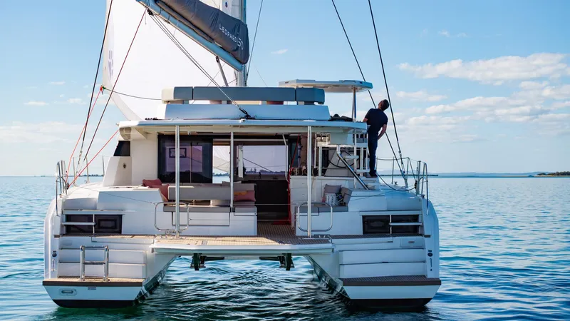  Yacht Photos Pics 2024 Leopard 50 catamaran sailing on calm waters under a clear blue sky.