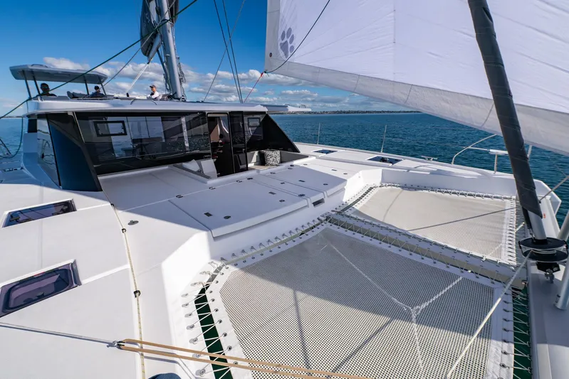  Yacht Photos Pics 2024 Leopard 50 catamaran sailing on open sea under clear blue sky.