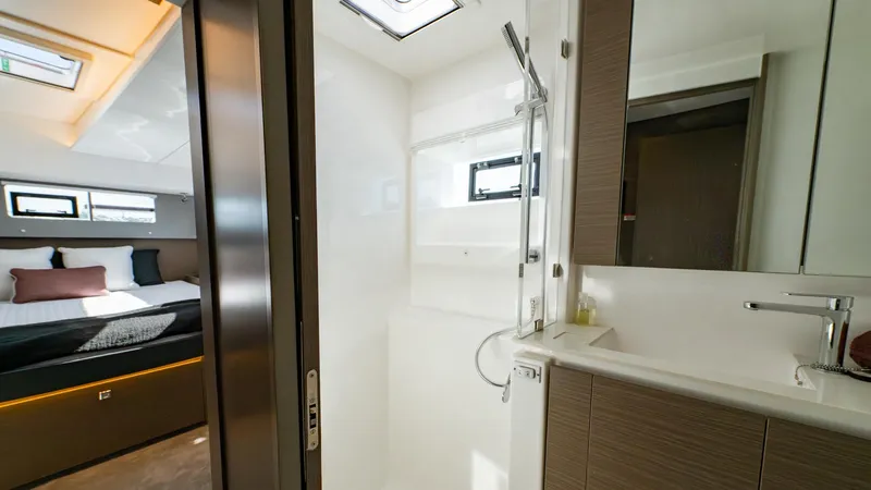  Yacht Photos Pics Luxurious 2024 Leopard 50 yacht interior featuring modern bathroom and cozy bedroom.