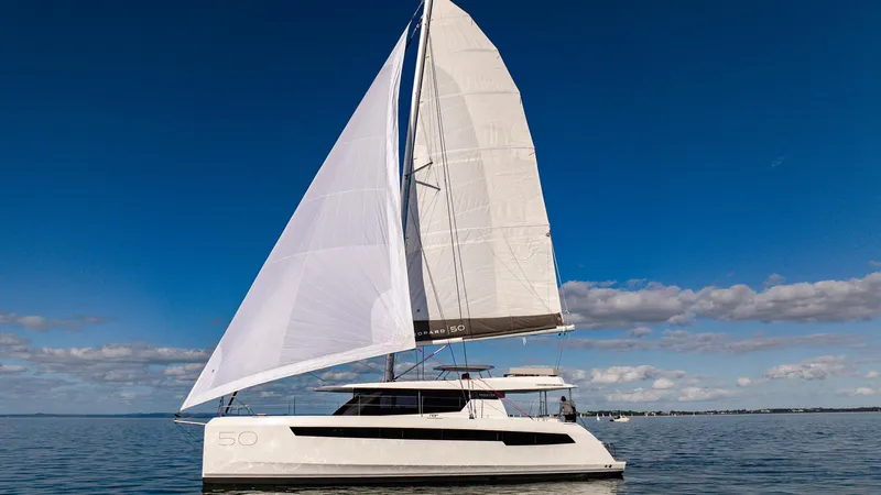 Yacht Photos Pics 2024 Leopard 50 sailing catamaran on open water under clear blue sky.