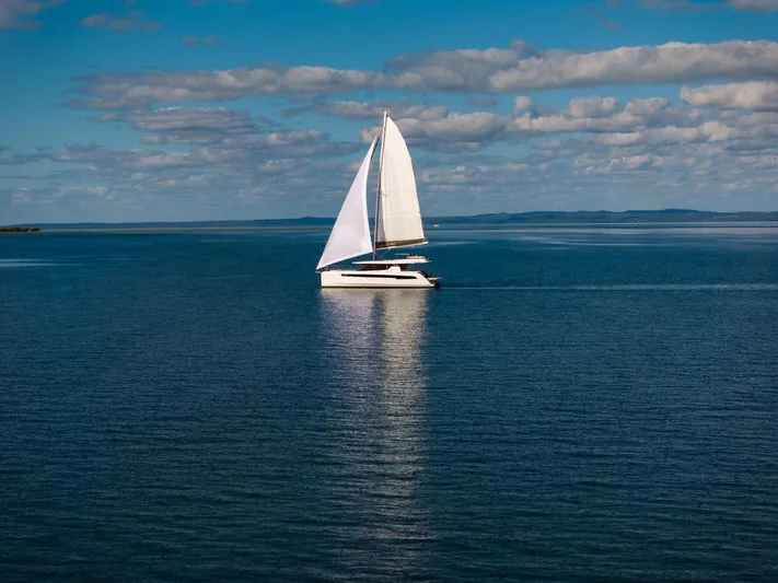  Yacht Photos Pics Sailing catamaran Leopard 50, 2024 model, gliding on calm blue waters under a clear sky.