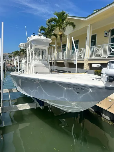  Yacht Photos Pics 2024 SeaVee 270Z boat docked near a waterfront building under a clear blue sky.