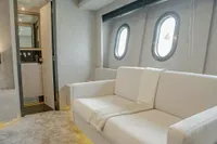 Luxury interior of 2006 Arno Leopard 31 OPEN yacht with white sofa and porthole windows.