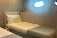 Cozy cabin interior of 2006 Arno Leopard 31 OPEN yacht with single bed and porthole.