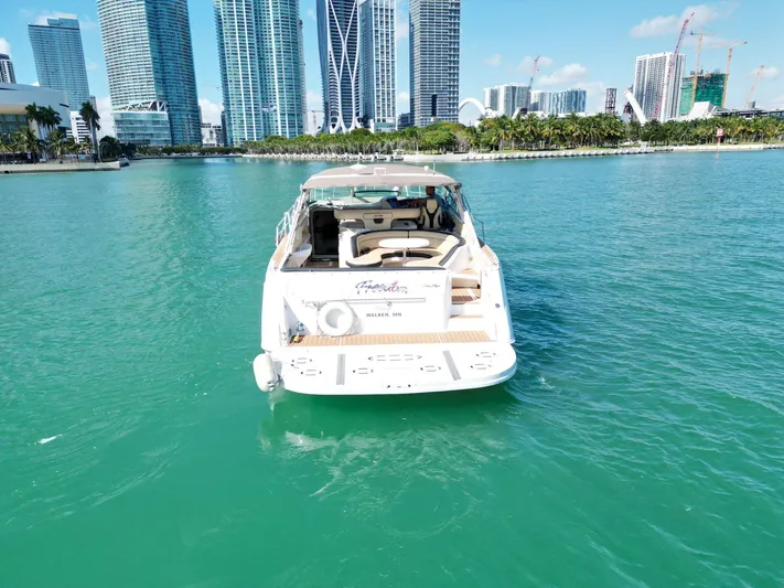  Yacht Photos Pics 1998 Sea Ray 500 Sundancer yacht on turquoise water with city skyline backdrop.