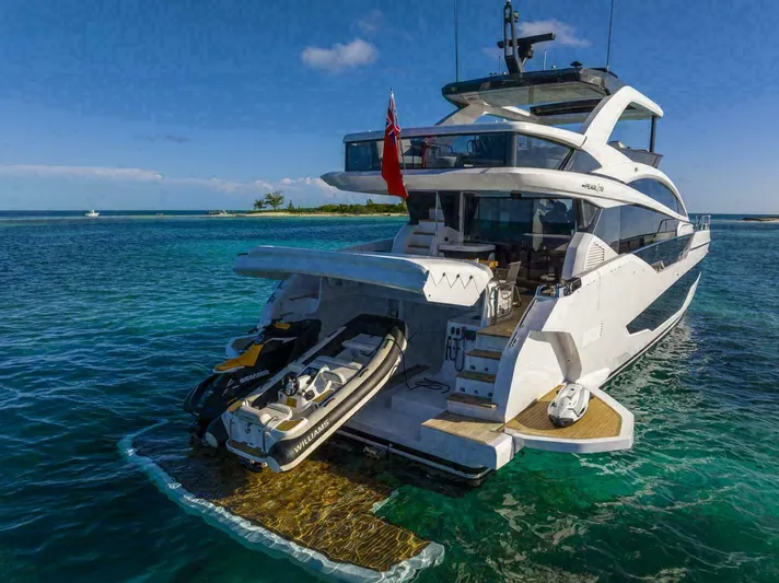 Pearl 72 Indulgence Yacht Photos Pics Luxurious 2025 Pearl 72 yacht with jet ski, anchored in clear blue waters.