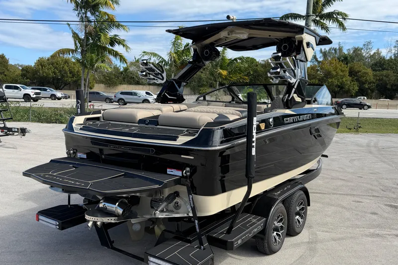  Yacht Photos Pics 2026 Centurion Ri230 boat on trailer, sleek black design, parked outdoors.