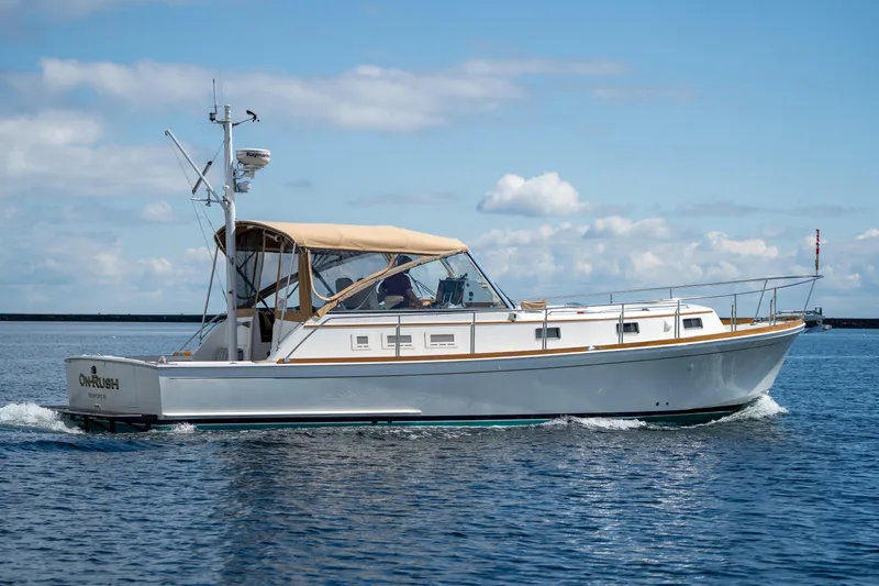 On-rush Yacht Photos Pics 2000 Grand Banks Eastbay 43 Ex cruising on calm waters under a clear sky.