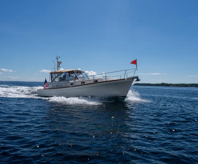 On-rush Yacht Photos Pics Grand Banks Eastbay 43 Ex 2000 cruising on open water under clear blue sky.