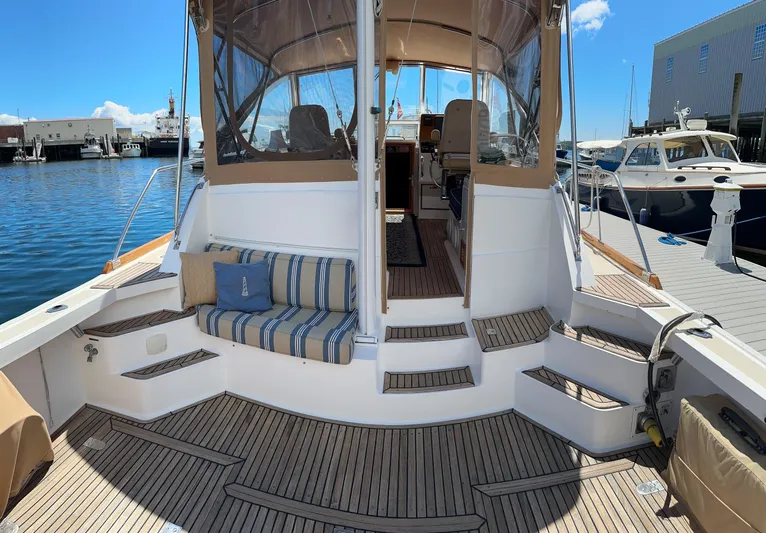 On-rush Yacht Photos Pics Grand Banks Eastbay 43 Ex 2000 yacht with teak deck and striped seating at marina.