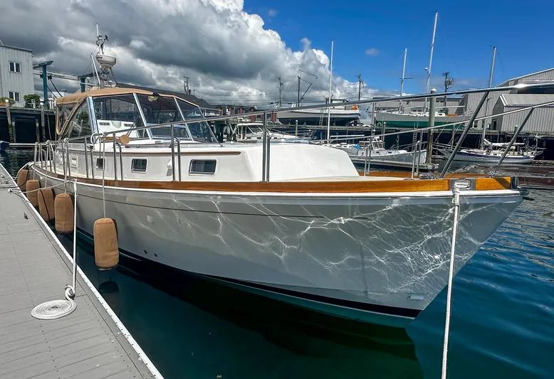 On-rush Yacht Photos Pics 2000 Grand Banks Eastbay 43 Ex docked at marina under cloudy sky.