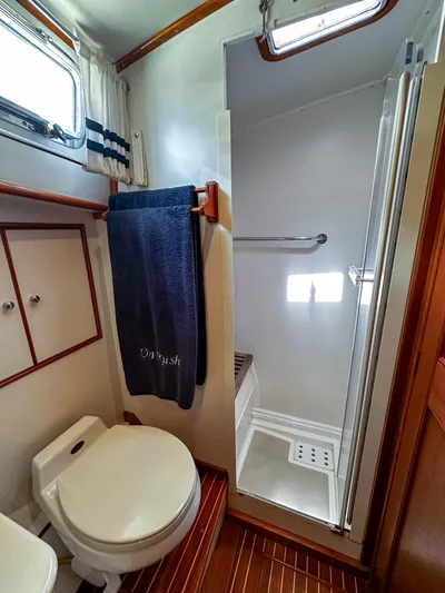 On-rush Yacht Photos Pics Bathroom of 2000 Grand Banks Eastbay 43 Ex with shower, toilet, and storage cabinets.