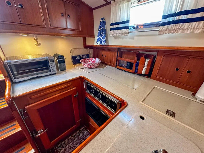 On-rush Yacht Photos Pics 2000 Grand Banks Eastbay 43 Ex galley with wooden cabinets and modern appliances.