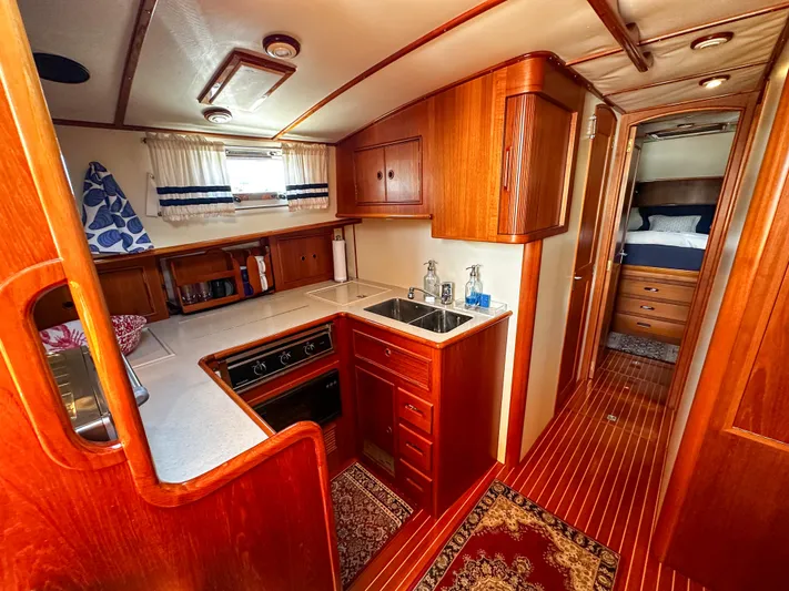 On-rush Yacht Photos Pics Luxurious 2000 Grand Banks Eastbay 43 Ex yacht interior with wooden cabinetry and modern kitchen.