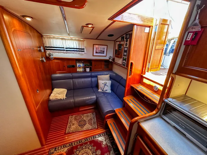 On-rush Yacht Photos Pics Interior of 2000 Grand Banks Eastbay 43 Ex with cozy seating area and wooden finishes.