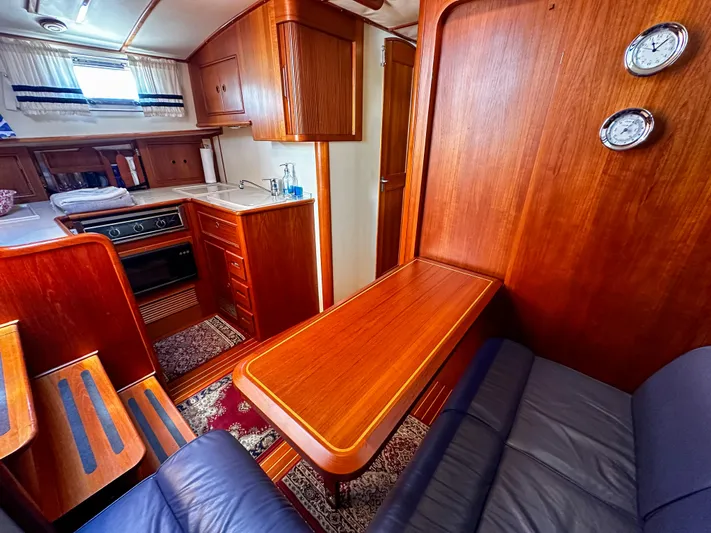 On-rush Yacht Photos Pics Interior of 2000 Grand Banks Eastbay 43 Ex yacht with wooden cabinetry and cozy seating area.