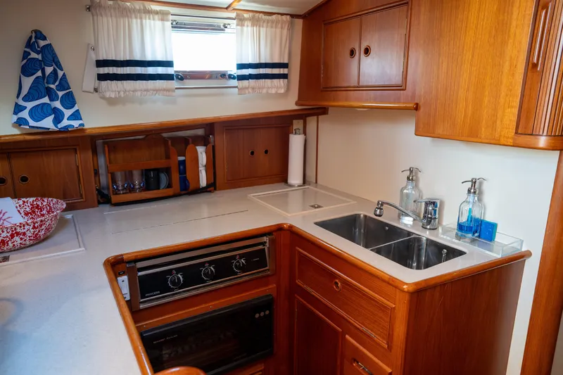 On-rush Yacht Photos Pics 2000 Grand Banks Eastbay 43 Ex galley with wood cabinetry, sink, and stove.