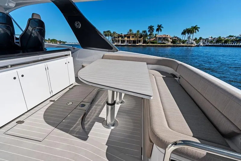  Yacht Photos Pics 2024 Azimut Verve 42 yacht interior with seating and table, overlooking waterfront homes.
