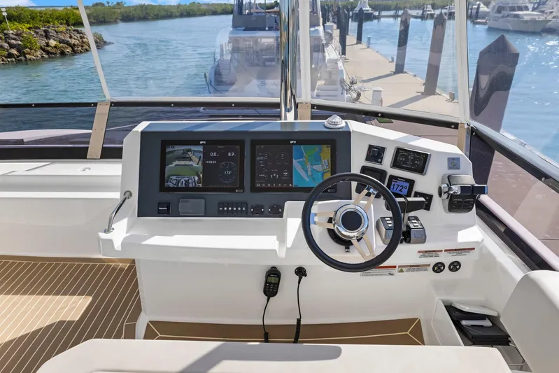 Prelude Yacht Photos Pics 2024 Leopard 46 Powercat helm with navigation screens and steering wheel, docked in marina.