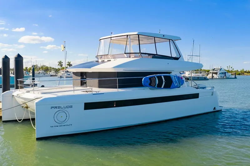 Prelude Yacht Photos Pics 2024 Leopard 46 Powercat yacht docked, featuring sleek design and paddleboards on deck.
