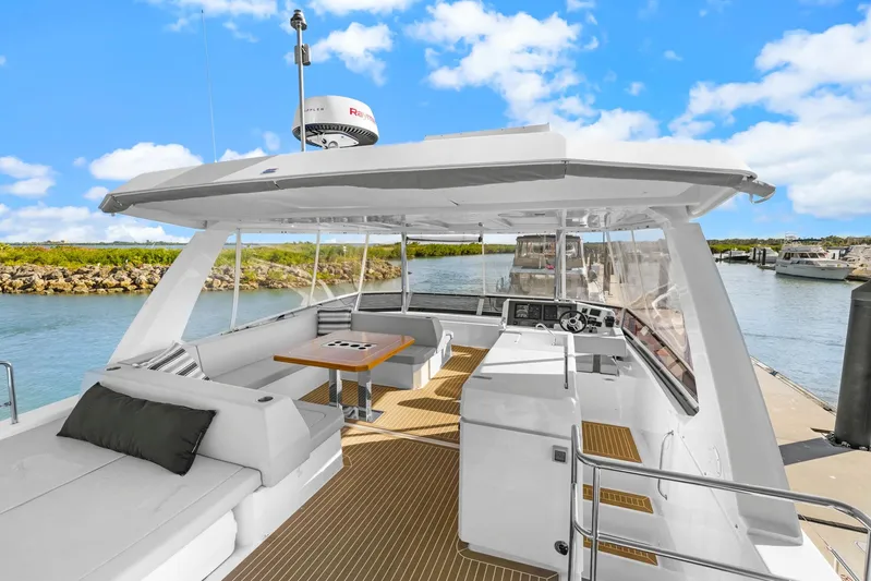 Prelude Yacht Photos Pics 2024 Leopard 46 Powercat yacht with spacious deck and modern design, docked in a scenic marina.