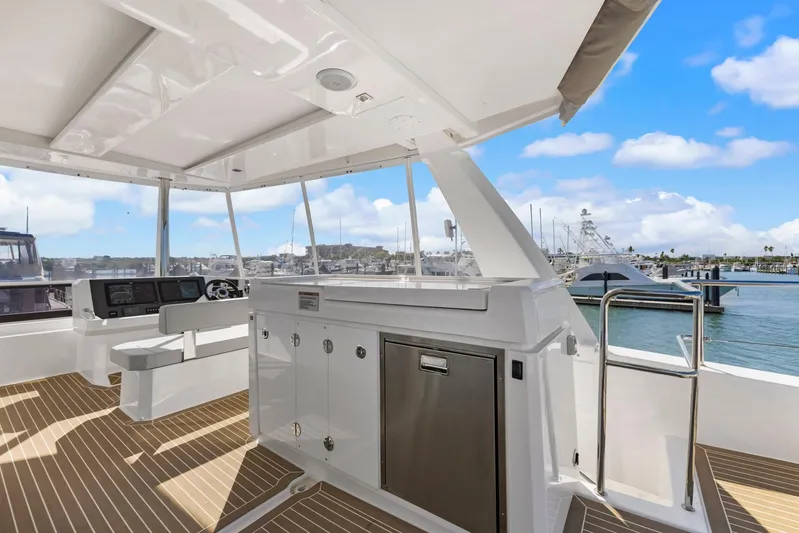 Prelude Yacht Photos Pics 2024 Leopard 46 Powercat yacht interior with helm, cabinetry, and ocean view.