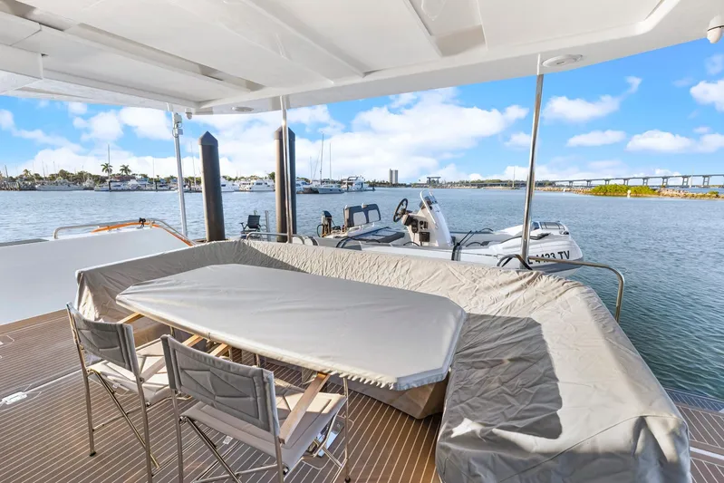 Prelude Yacht Photos Pics 2024 Leopard 46 Powercat deck with covered seating, overlooking marina and boats.