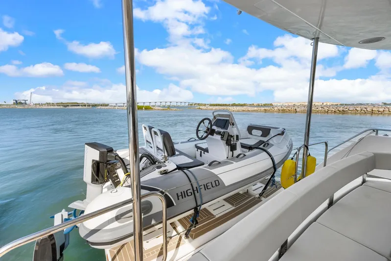 Prelude Yacht Photos Pics 2024 Leopard 46 Powercat with dinghy on calm water, clear sky background.