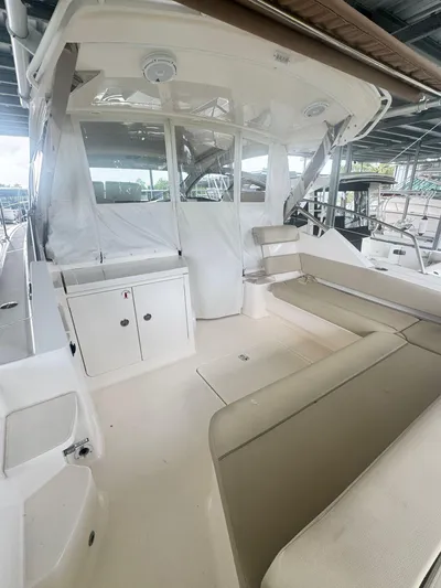  Yacht Photos Pics 2016 Pursuit SC 365i Sport Coupe interior with seating and storage under a covered dock.