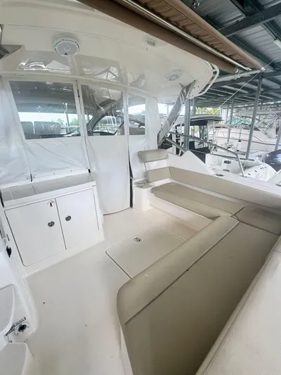  Yacht Photos Pics 2016 Pursuit SC 365i Sport Coupe interior with seating and storage under a covered dock.