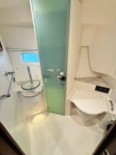  Yacht Photos Pics 2016 Pursuit SC 365i Sport Coupe bathroom with modern fixtures and frosted glass door.