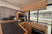 Modern kitchen interior of 2020 Lagoon 42 yacht with appliances and wooden cabinetry.
