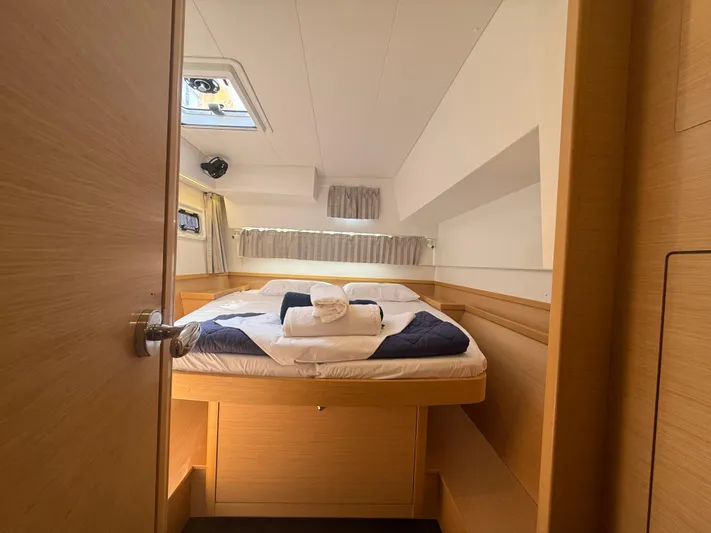 La Mer Yacht Photos Pics Cozy cabin interior of 2020 Lagoon 42 yacht with neatly arranged bed and natural light.