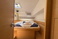 Cozy cabin interior of 2020 Lagoon 42 yacht with neatly arranged bed and natural light.