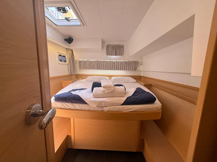 La Mer Yacht Photos Pics Cozy cabin interior of 2020 Lagoon 42 catamaran with neatly arranged bed and natural light.