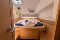 Cozy cabin interior of 2020 Lagoon 42 catamaran with neatly arranged bed and natural light.