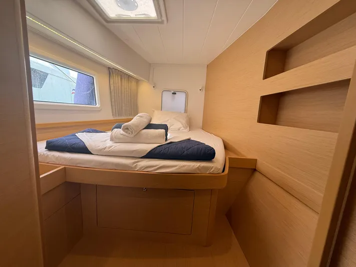 La Mer Yacht Photos Pics Cozy cabin interior of 2020 Lagoon 42 catamaran with bed and window view.