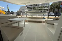 Interior view of 2020 Lagoon 42 catamaran with seating and table, docked at marina.