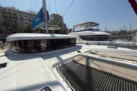 2020 Lagoon 42 catamaran docked in a marina, featuring spacious deck and modern design.