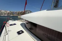 2020 Lagoon 42 catamaran docked in a marina with cityscape background.