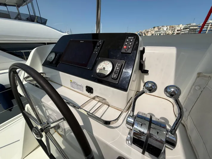 La Mer Yacht Photos Pics Steering wheel and controls of a 2020 Lagoon 42 yacht, docked in a marina.