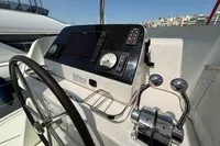 Steering wheel and controls of a 2020 Lagoon 42 yacht, docked in a marina.