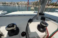 Deck view of a 2020 Lagoon 42 catamaran in a marina, featuring winches and ropes.