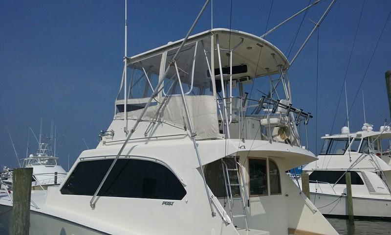 1984 Post Convertible boat docked, featuring a spacious upper deck and sleek design.